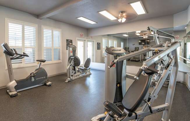 A gym with a treadmill, elliptical trainer and a weight machine at Autumn Oaks Apartments, Roseville, CA, 95678
