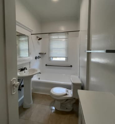 A white bathroom with a toilet, sink, and bathtub.