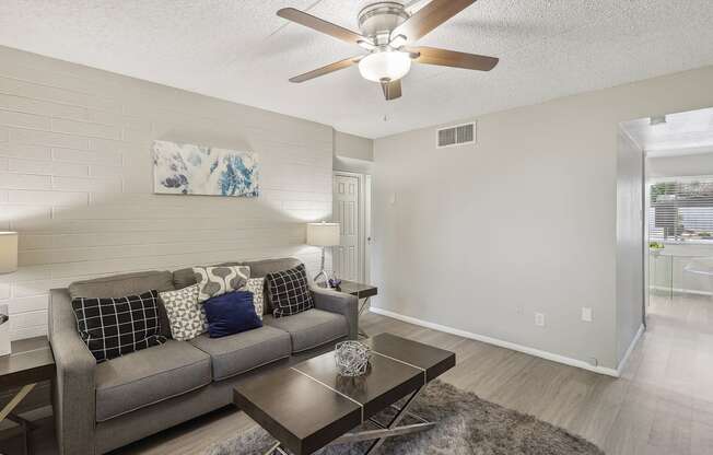 a living room with a couch and a ceiling fan