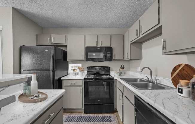 A kitchen with a black refrigerator and a black oven.