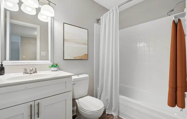 A bathroom with a toilet, sink, and shower.