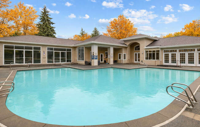 A large swimming pool in front of a house.