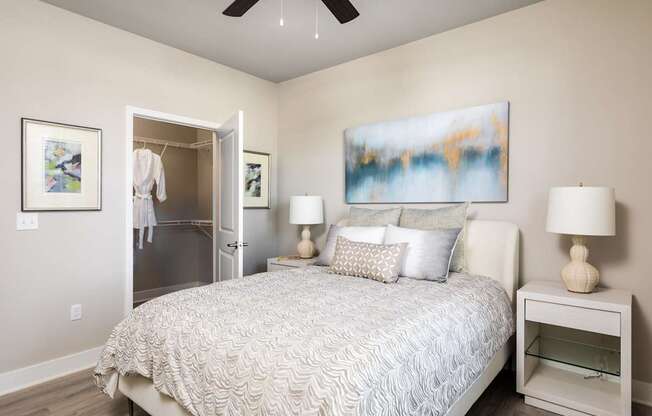 A bedroom with a large bed and a painting on the wall.