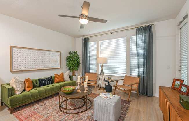 a living room with a green couch and a large window