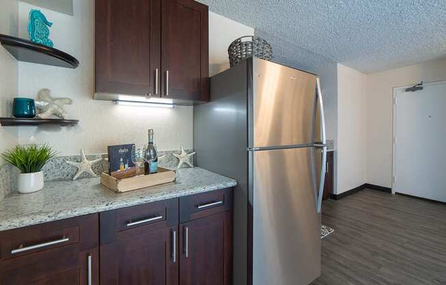 Waikiki Walina Apartments entry way and kitchen area with appliances, cabinets, and counters