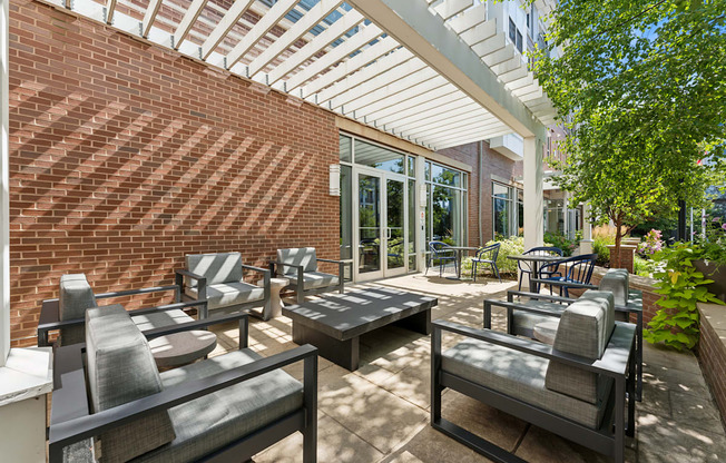 a patio with tables and chairs and a brick wall