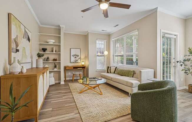 A living room with a white couch, a green chair, and a wooden cabinet.