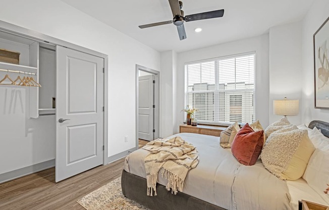 a bedroom with a large bed and a ceiling fan at Meridian at CityPlace, Woodbury, MN 55125