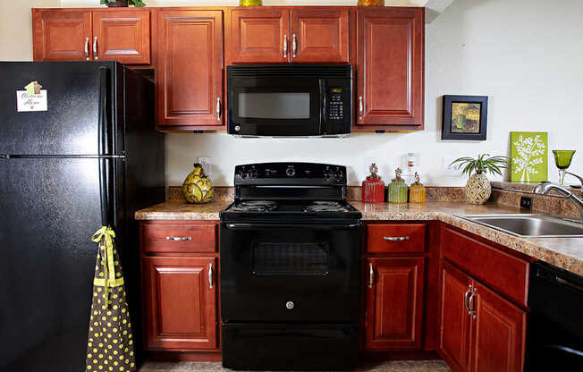 A black refrigerator with a yellow and black bag hanging on it.