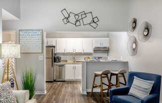 A modern kitchen with a bar stool and a chair.