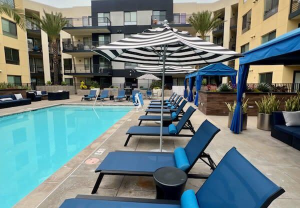 a row of blue lounge chairs next to a swimming pool