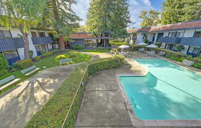 a backyard with a pool and a building with trees