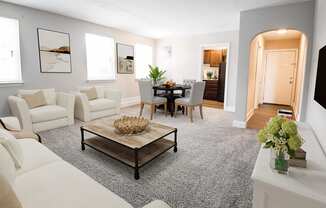 a living room with grey carpet and white furniture