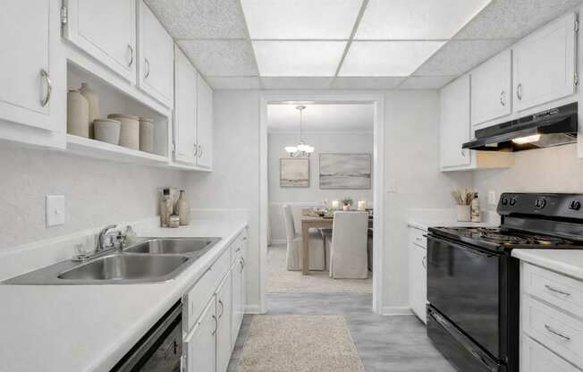 A kitchen with white cabinets and a black stove top oven.