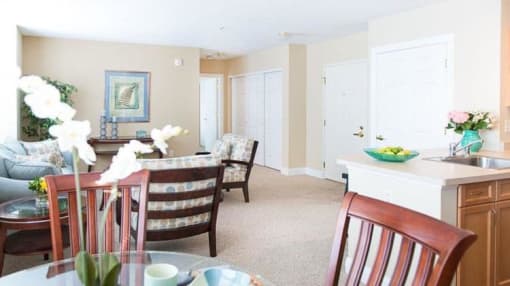 View from dining area of great room towards front entrance, living area, and kitchen area