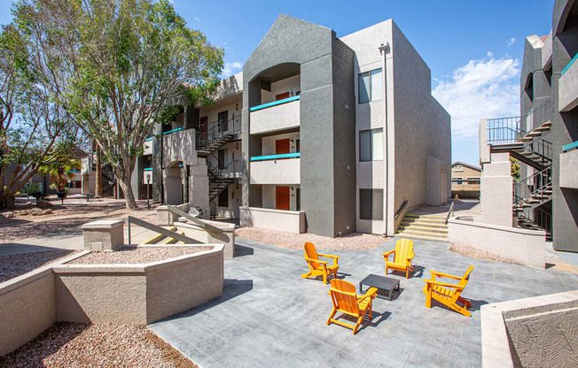 A modern building with a courtyard and yellow chairs.