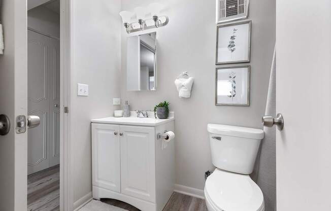 a white bathroom with a toilet and a sink