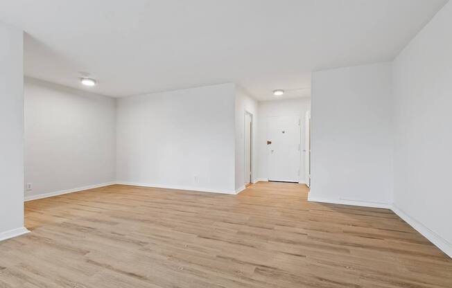 A room with wooden flooring and white walls.