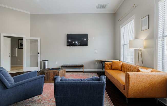 a living room with couches and chairs and a television