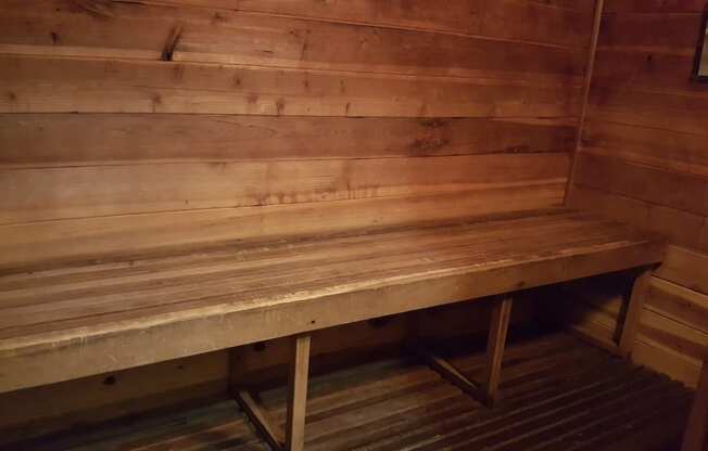the sauna has a wooden bench and a wooden floor