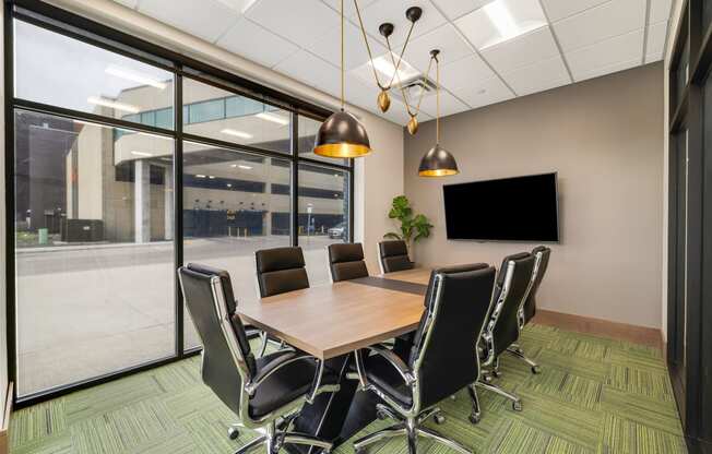 a conference room with a table and chairs and a tv