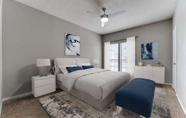 A bedroom with a bed, nightstand, and a ceiling fan.