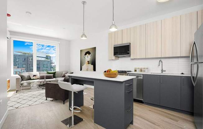A modern kitchen with a large island and a view of the city.