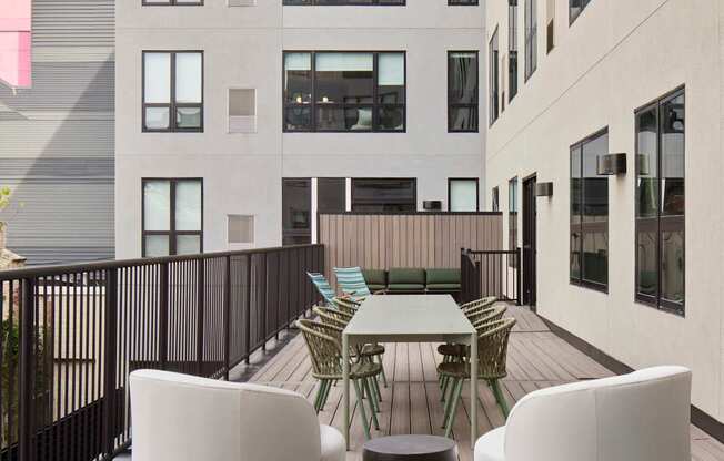 A patio with a table and chairs overlooking a building.
