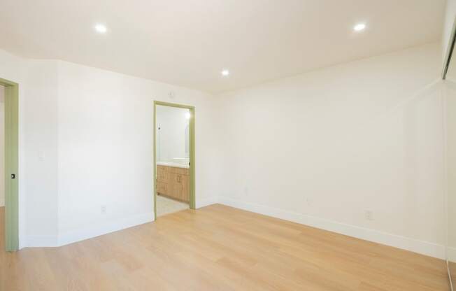 a living room with white walls and a wooden floor
