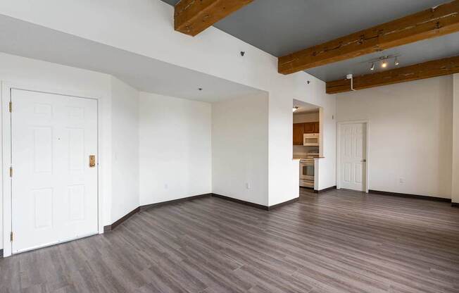 A room with a white door and wooden beams on the ceiling.