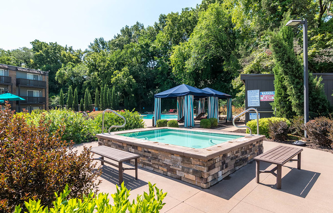 A pool area with a blue canopy and benches.