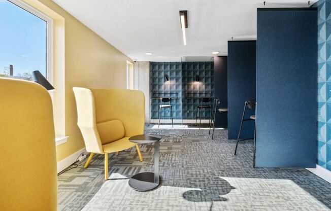a lobby with yellow chairs and a blue and white rug at The Box, Richmond, VA