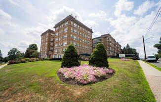 a park with flowers and trees in front of a building at The Packard, Connecticut