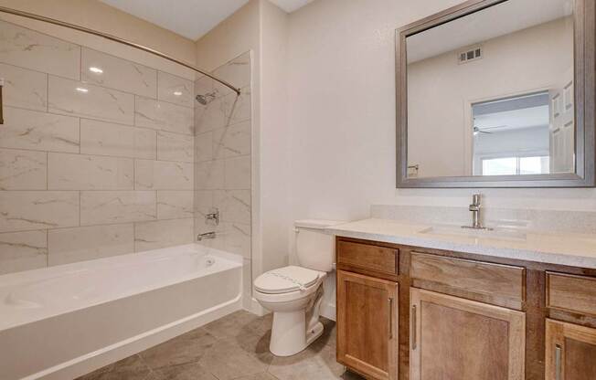 A bathroom with a white toilet and a white bathtub.