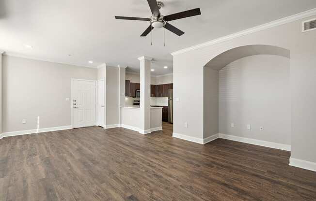 an empty living room with a ceiling fan and a kitchen at The Verandah, Austin, 78726