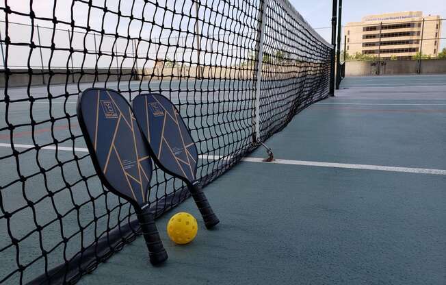 two tennis rackets and a ball on a tennis court