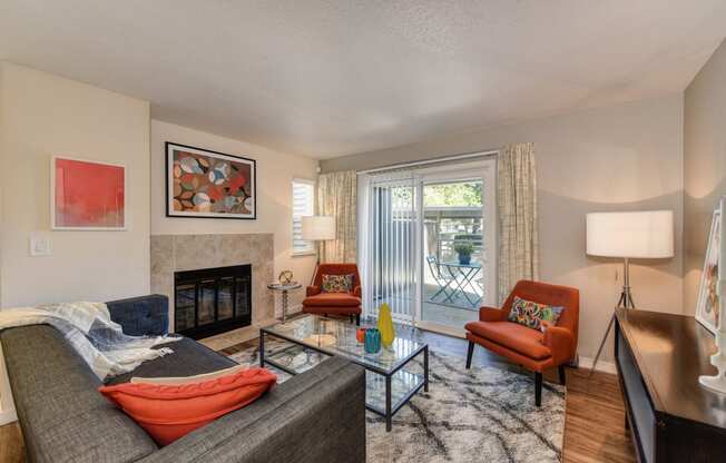 Living Room and Entryway withWood Inspired Floors,  Orange Chair, Hardwood Inspired Floor, Gray Sofa, Black/White Rug 