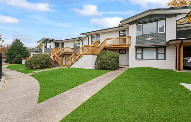 the front of a house with a yard and a staircase