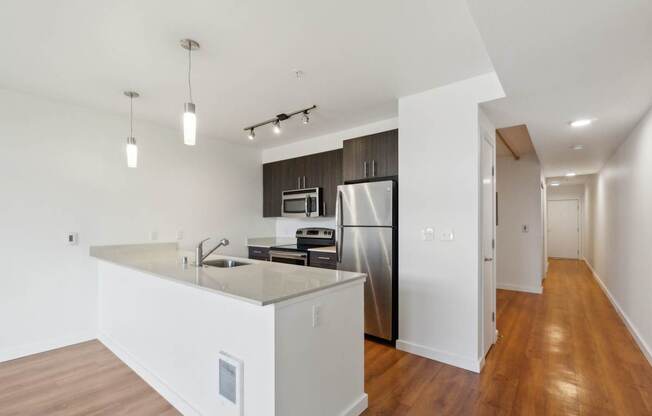 A modern kitchen with a refrigerator, sink, and microwave.