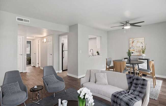 Model Living Room with Wood-Style Flooring and View of Kitchen/Dining Area at Overlook Point Apartments in Salt Lake City, UT.