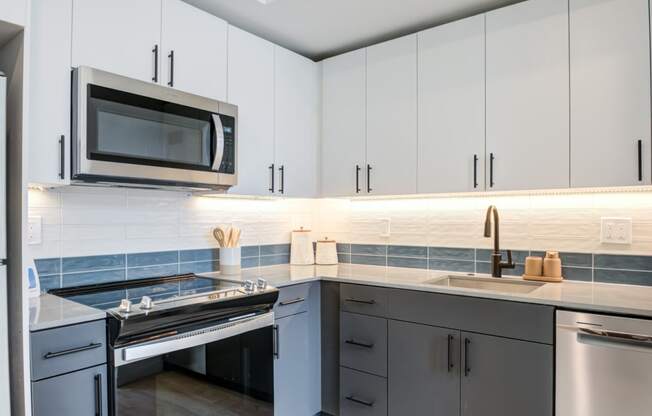 a kitchen with white cabinets and a stove and a microwave