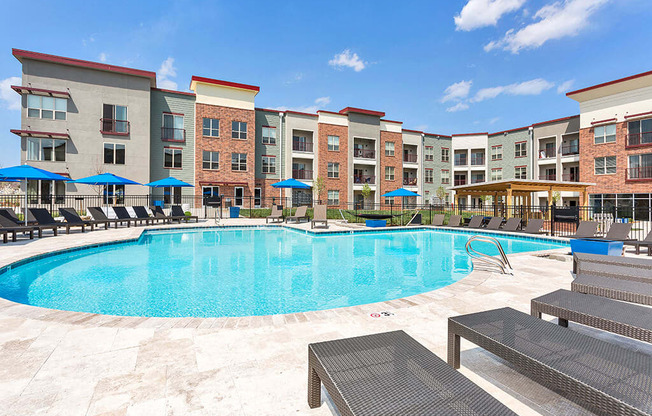 Westlake Greens Pool with grey lounge chairs and blue umbrellas