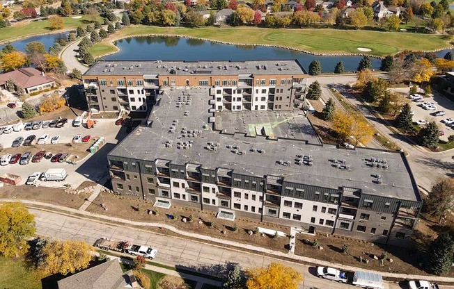 an aerial view of a building next to a lake