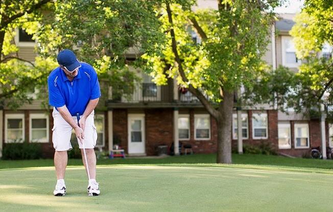 a man in a blue shirt is playing golf