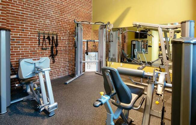 Lofts at Lafayette Square fitness center with equipment and wall mirror