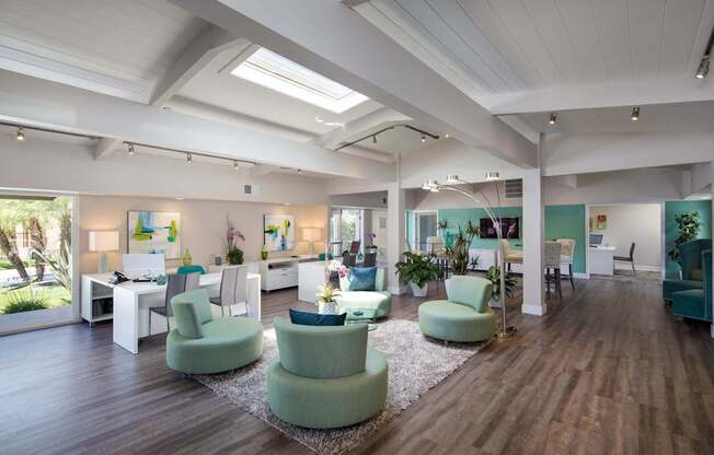 A spacious room with green chairs and wooden floors.