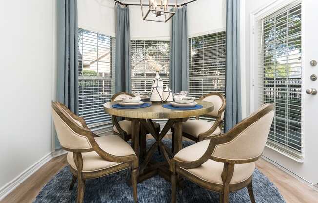 a dining area with a round table and four chairs