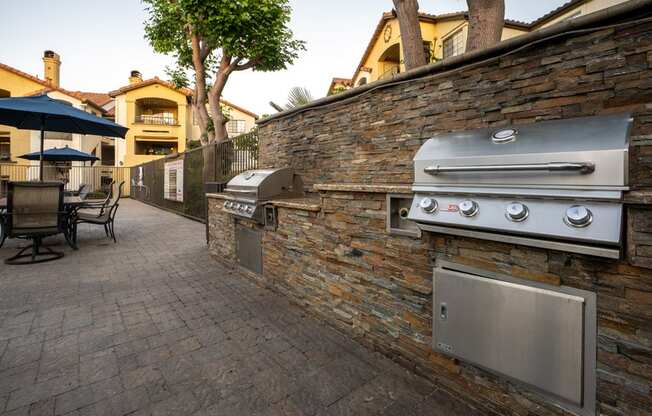 A stone wall with a built in BBQ grill.