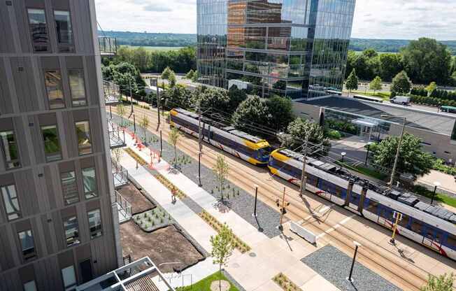 A train is passing by a modern building.