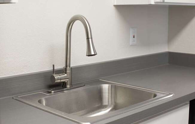 A modern kitchen sink with a chrome faucet.